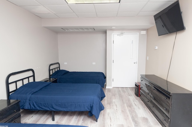 bedroom featuring light hardwood / wood-style flooring and a drop ceiling