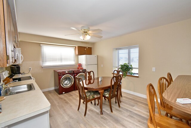 dining room featuring light hardwood / wood-style floors, washer and clothes dryer, and a healthy amount of sunlight