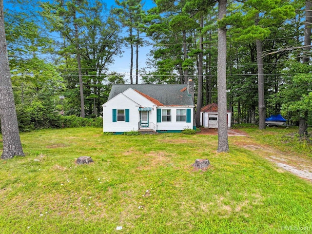 view of front facade featuring a front lawn and an outbuilding