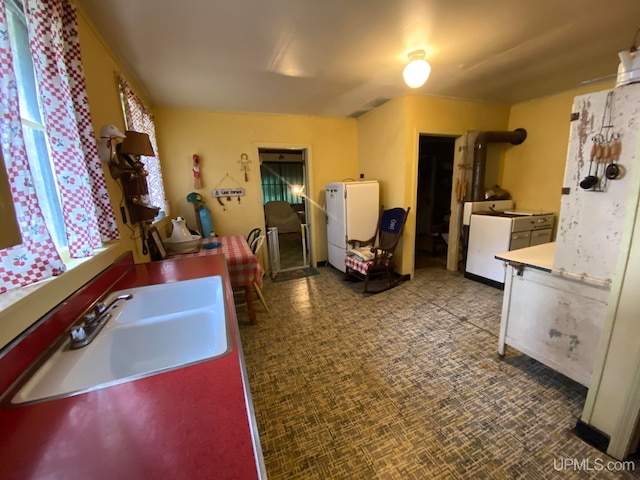 kitchen with sink, white fridge, and light tile patterned floors