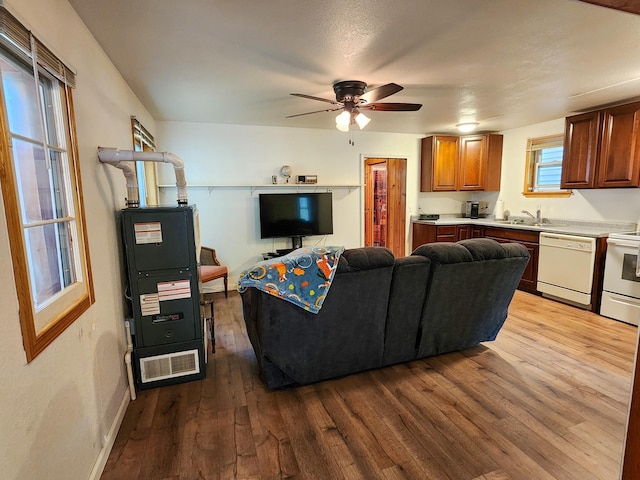 living room with baseboards, a ceiling fan, and wood finished floors