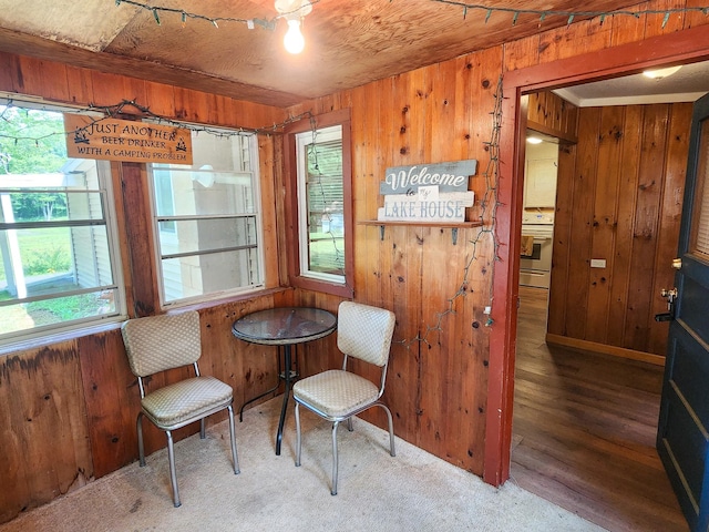 sitting room with hardwood / wood-style floors and wooden walls