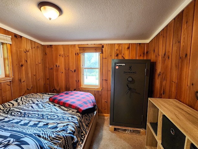 bedroom featuring wood walls, a textured ceiling, and carpet