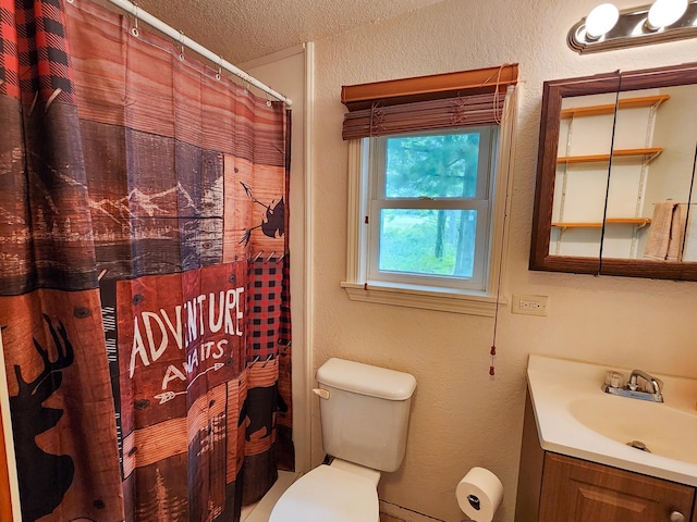 full bathroom featuring toilet, vanity, a textured ceiling, and curtained shower