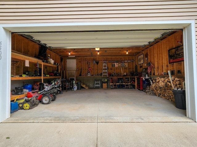 garage featuring wood walls and a workshop area