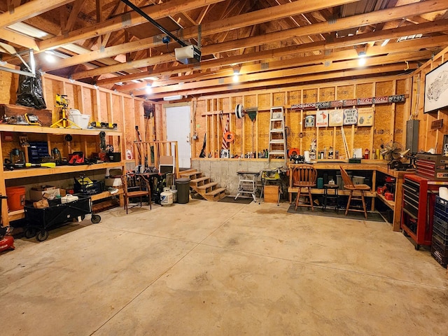 garage with a garage door opener and a workshop area