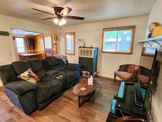 living room with baseboards, a ceiling fan, and wood finished floors