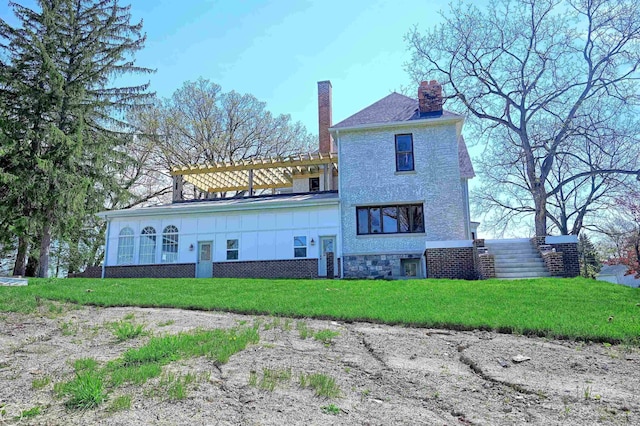 rear view of house featuring a pergola and a yard