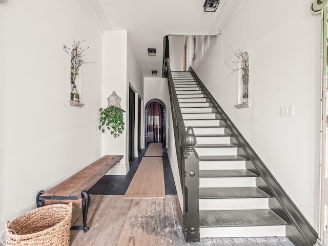 stairway featuring crown molding and hardwood / wood-style floors