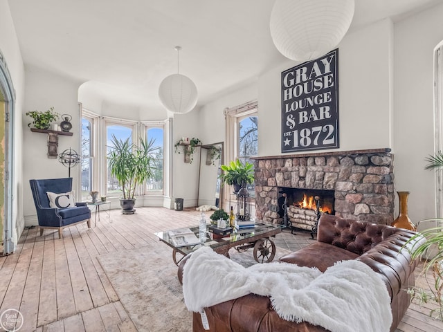 living room featuring a stone fireplace and hardwood / wood-style floors