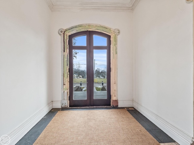 entryway with crown molding and french doors