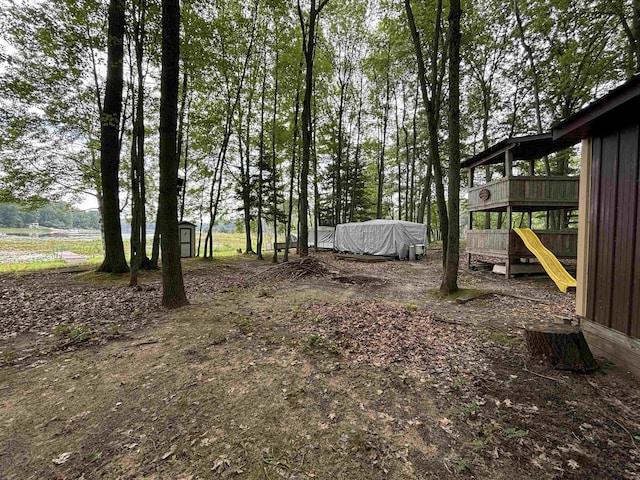 view of yard featuring a playground and a storage shed