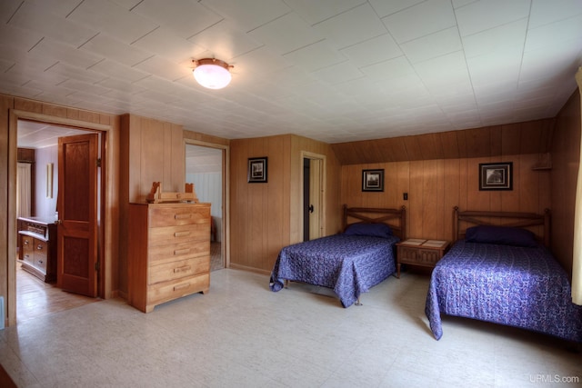 bedroom featuring wooden walls and light tile patterned floors