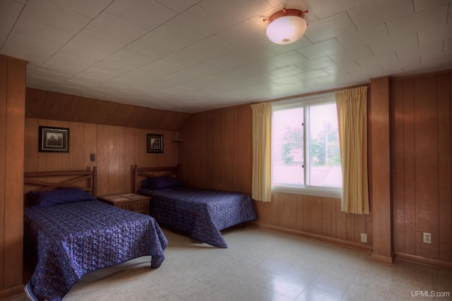 bedroom featuring wood walls, light tile patterned flooring, and lofted ceiling