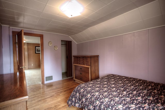 bedroom with lofted ceiling and light hardwood / wood-style floors