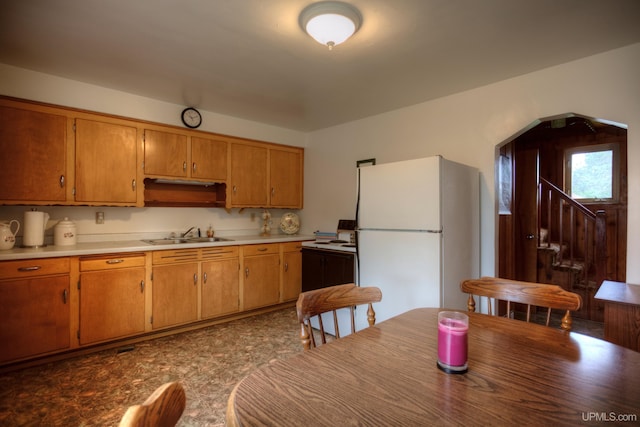 kitchen with tile patterned floors, white refrigerator, and sink