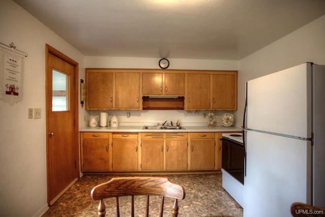 kitchen featuring sink, dark tile patterned flooring, and white refrigerator