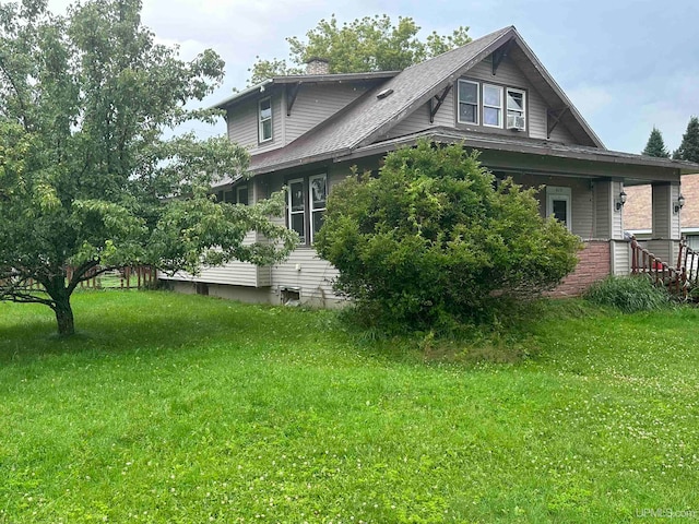 view of side of home with a yard