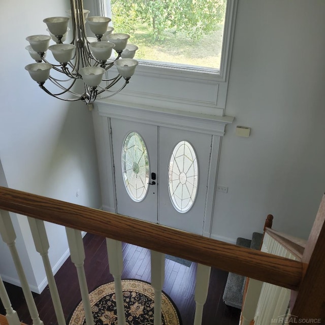 entryway with hardwood / wood-style floors and a notable chandelier