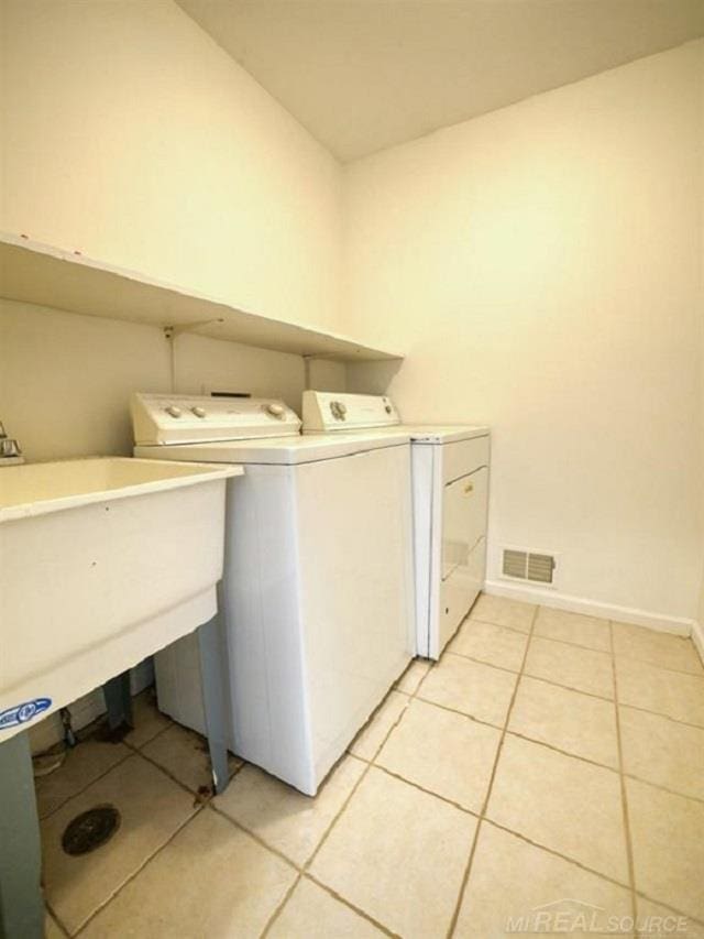 clothes washing area featuring light tile patterned floors and independent washer and dryer