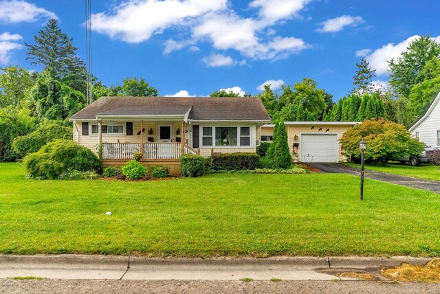 single story home with a garage, a front yard, and covered porch