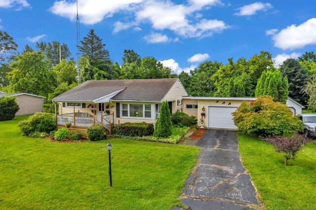 single story home featuring a garage, a front yard, and covered porch