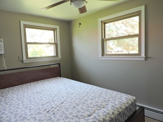 carpeted bedroom featuring a baseboard heating unit, multiple windows, and ceiling fan