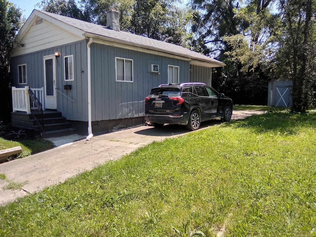 view of side of property featuring a shed and a yard