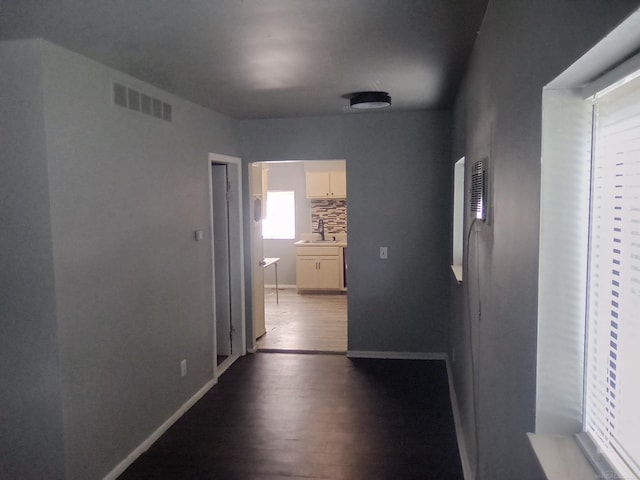 hall with hardwood / wood-style flooring and sink