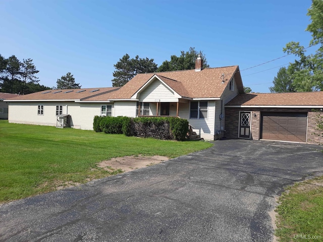 single story home featuring a garage and a front lawn