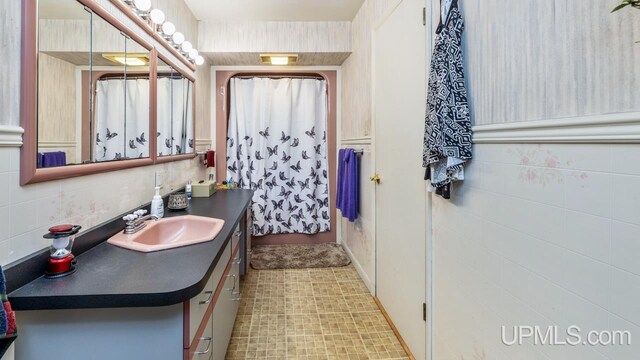 bathroom featuring vanity, tile patterned flooring, and tile walls