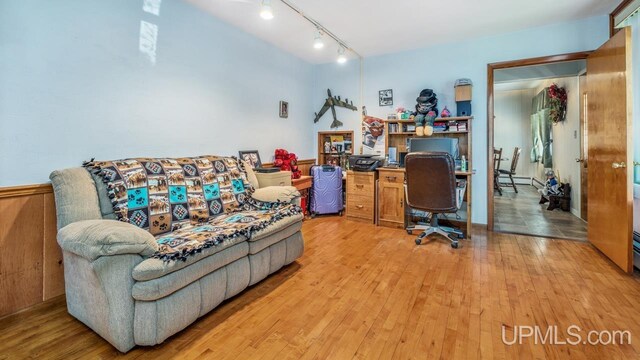 office space with light hardwood / wood-style floors and rail lighting