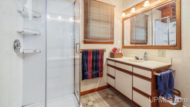 bathroom featuring tile patterned floors, a shower with door, and vanity