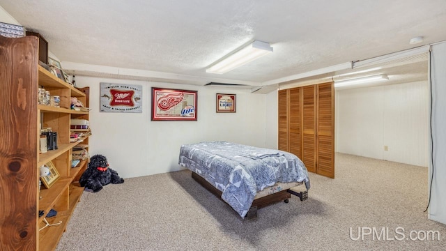 carpeted bedroom with a textured ceiling and a closet