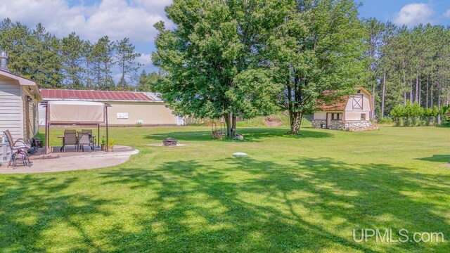 view of yard with a patio, a shed, and a fire pit