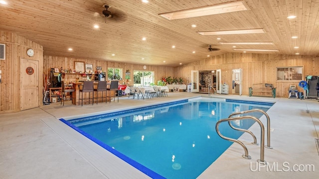 view of swimming pool featuring ceiling fan and a skylight