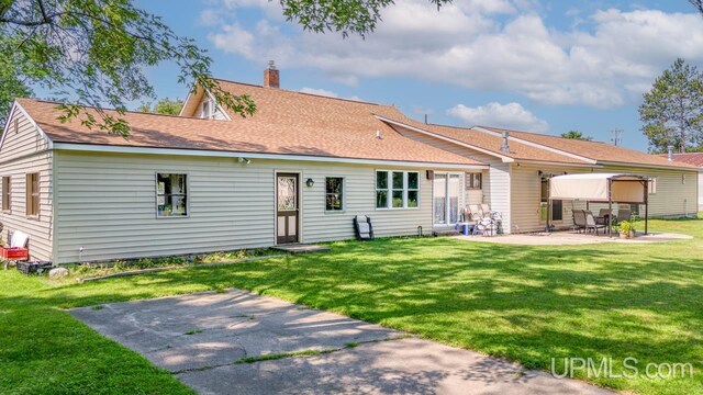 rear view of house with a patio and a yard