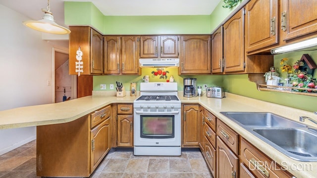 kitchen featuring white stove, sink, kitchen peninsula, decorative light fixtures, and light tile patterned floors