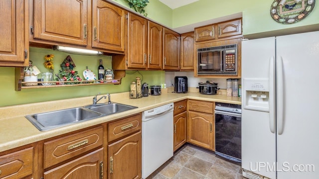 kitchen featuring sink, light tile patterned floors, and white appliances