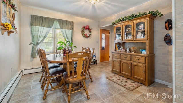 dining area featuring baseboard heating, brick wall, and light tile patterned floors