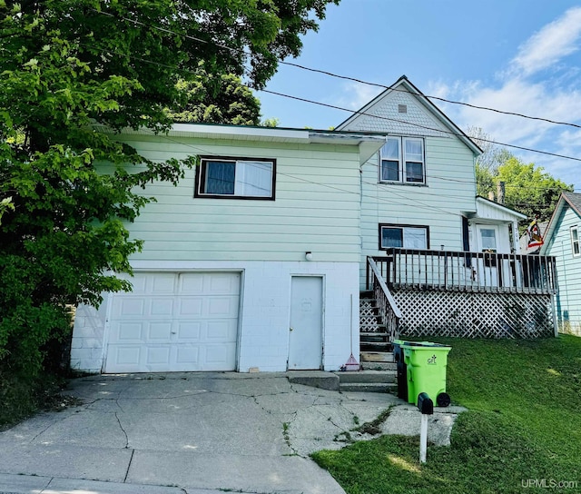 view of front facade with a wooden deck, a garage, and a front yard