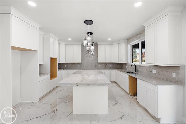 kitchen with marble finish floor, recessed lighting, a sink, and a center island