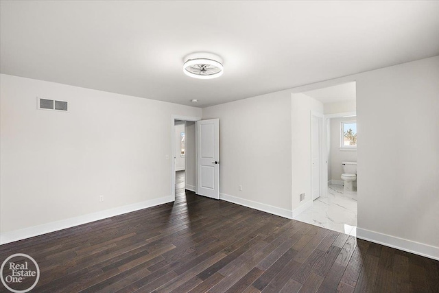 unfurnished bedroom with visible vents, baseboards, and wood finished floors