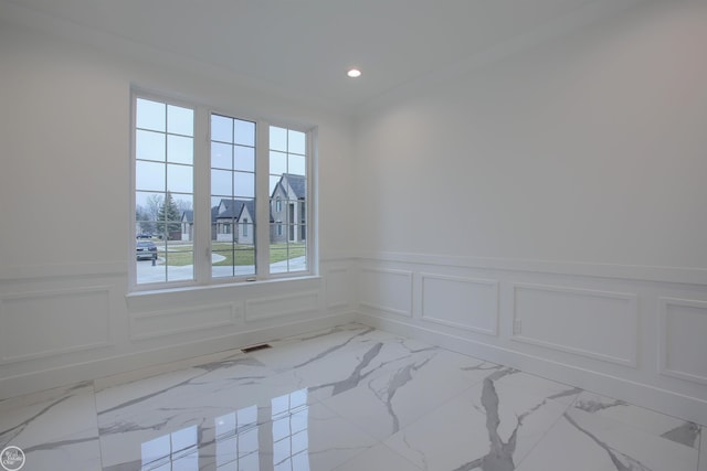 empty room featuring visible vents, marble finish floor, recessed lighting, wainscoting, and a decorative wall