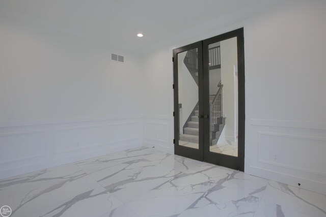 interior space featuring visible vents, recessed lighting, french doors, wainscoting, and a decorative wall