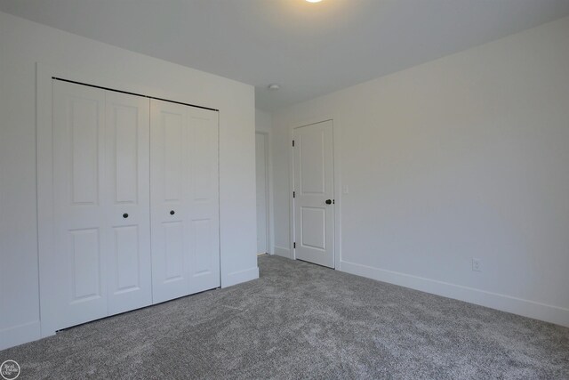 unfurnished bedroom with a closet, carpet flooring, and baseboards