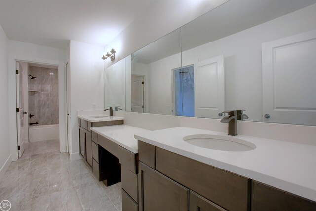 bathroom featuring tiled shower / bath combo and vanity