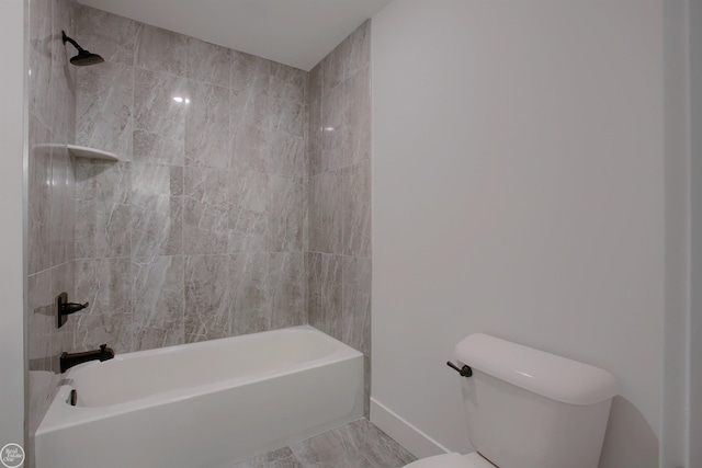 bathroom featuring tiled shower / bath combo and toilet