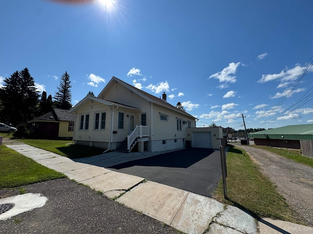 view of front facade featuring an outbuilding, a garage, and a front lawn