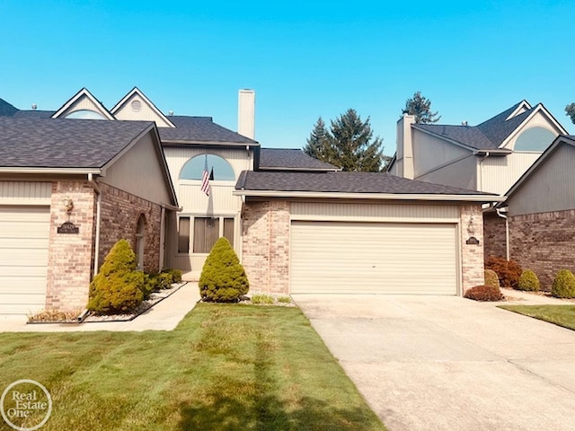 view of front facade with driveway, a front yard, brick siding, and an attached garage